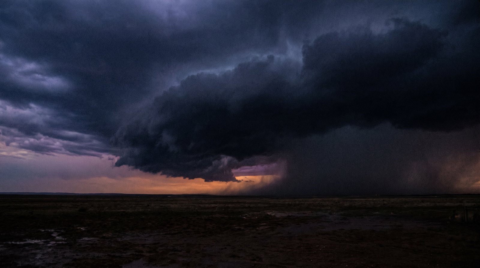 Storm front closing off the last horizon light over the operations lane